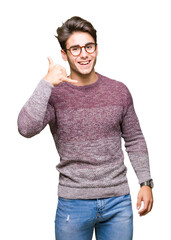 Young handsome man wearing glasses over isolated background smiling doing phone gesture with hand and fingers like talking on the telephone. Communicating concepts.