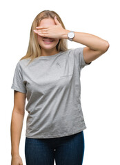 Fototapeta premium Young caucasian woman over isolated background smiling and laughing with hand on face covering eyes for surprise. Blind concept.