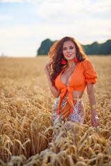 A beautiful woman with long hair posing in a field of wheat. conceptual fashion image.