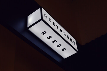 A luminous rectangular sign with "RESTROOMS" and "ASEOS" indicates convenient facilities with clarity