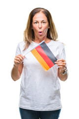 Middle age hispanic woman holding flag of Germany over isolated background scared in shock with a surprise face, afraid and excited with fear expression