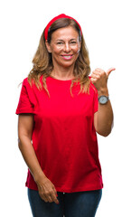 Obraz na płótnie Canvas Middle age senior hispanic woman over isolated background smiling with happy face looking and pointing to the side with thumb up.