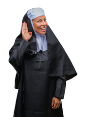 Middle age senior christian catholic nun woman over isolated background smiling with hand over ear listening an hearing to rumor or gossip. Deafness concept.