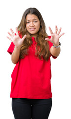 Young beautiful brunette woman wearing red t-shirt over isolated background afraid and terrified with fear expression stop gesture with hands, shouting in shock. Panic concept.