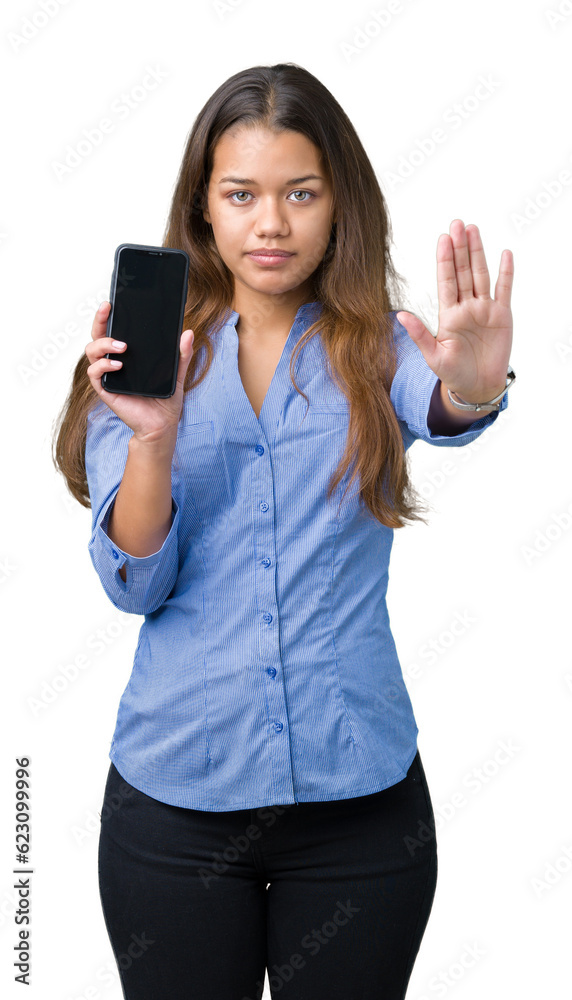 Canvas Prints Young beautiful brunette business woman showing screen of smartphone over isolated background with open hand doing stop sign with serious and confident expression, defense gesture