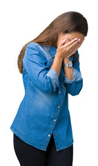 Young beautiful brunette woman wearing blue denim shirt over isolated background with sad expression covering face with hands while crying. Depression concept.