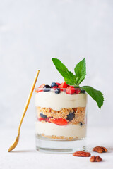 Dessert in a glass with berries, mint, whipped cream and biscuit. Healthy food, vegan, sugar, gluten and lactose free.