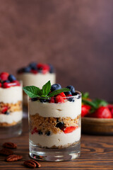 Dessert in a glasses with berries, mint, whipped coconut cream and biscuit. Healthy food, vegan, sugar, gluten and lactose free.