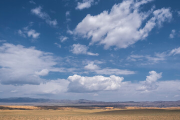 Cloudy sky over the steppe and desert mountains on hot summer day