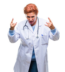 Senior caucasian doctor woman wearing medical uniform over isolated background shouting with crazy expression doing rock symbol with hands up. Music star. Heavy concept.