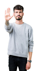 Naklejka premium Young handsome man wearing sweatshirt over isolated background doing stop sing with palm of the hand. Warning expression with negative and serious gesture on the face.