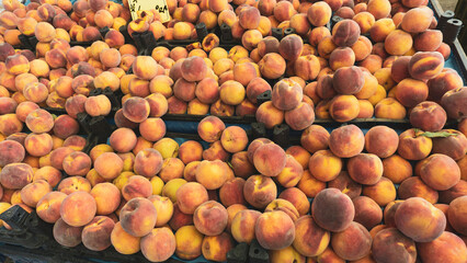 Orange peaches on the market bench or counter. Aegean or Mediterranean agricultural products background.