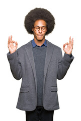 Young african american business man with afro hair wearing glasses relax and smiling with eyes closed doing meditation gesture with fingers. Yoga concept.