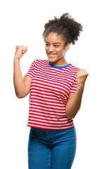 Young afro american woman over isolated background very happy and excited doing winner gesture with arms raised, smiling and screaming for success. Celebration concept.