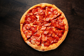 Pepperoni Pizza with Mozzarella cheese, salami, Tomato sauce, pepper, Spices. Italian pizza on wooden table background