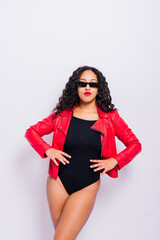 Sensual beautiful african ethnic woman in bodysuit posing in studio isolated on red white background