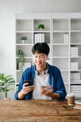 Man using smart phone for mobile payments online shopping,omni channel,sitting on table