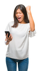 Young asian woman texting using smartphone over isolated background annoyed and frustrated shouting with anger, crazy and yelling with raised hand, anger concept