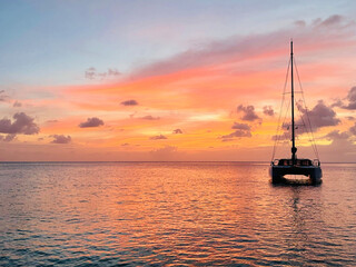 Coucher de soleil avec un catamaran dans les iles Grenadines - obrazy, fototapety, plakaty