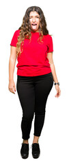 Young beautiful woman wearing casual t-shirt sticking tongue out happy with funny expression. Emotion concept.