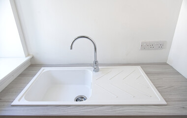 White basin with chrome mixer tap on vanity unit