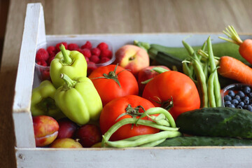 Wooden crate full of healthy seasonal fruit and vegetable. Selective focus, wooden background.
