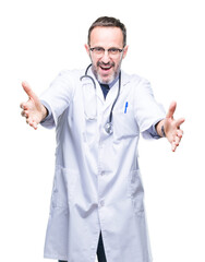 Middle age senior hoary doctor man wearing medical uniform isolated background looking at the camera smiling with open arms for hug. Cheerful expression embracing happiness.