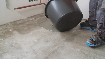  Leveling with cement mix for floors. Pours a liquid self-leveling floor onto a concrete base. Leveling the floor with mortar.