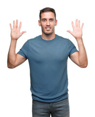 Naklejka premium Handsome young casual man showing and pointing up with fingers number ten while smiling confident and happy.