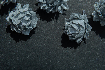 Christmas silver glitter rose ornament border on a black glitter background with copy space