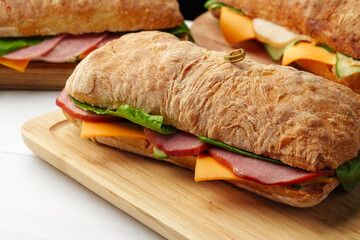 Chiabatta sandwich with ham and cheese on wooden board