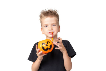 Halloween kids boy with pumpkin buckets eating candy on a white studio background. A happy boy holding Jack-o-pumpkin basket to collect candy trick or treat on Halloween day