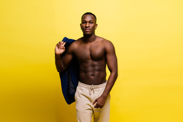 Portrait of an athletic african american man topless smiling, yellow, red and black background