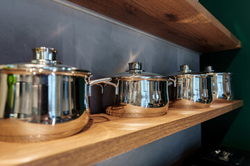 Shining new metal pots on open shelves in store