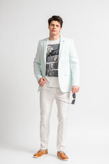 Fototapeta premium Man in casual business jacket and sunglasses posing on white background