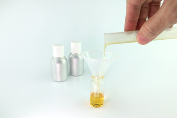 chemical beaker , flask is on white table with blotting paper , fragrance bottle and essential oil bottle are used to blend the nice scent for making perfume and candle by perfumer in the laboratory