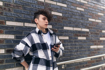 Fototapeta na wymiar young man with a phone against a brick wall