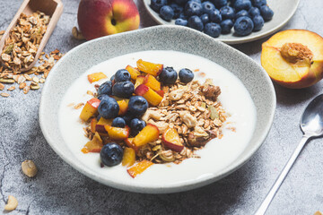 Granola with yogurt, peach, blueberries in a plate 