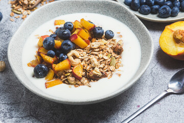 Granola with yogurt, peach, blueberries in a plate 