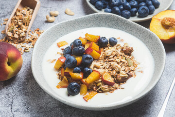 Granola with yogurt, peach, blueberries in a plate 