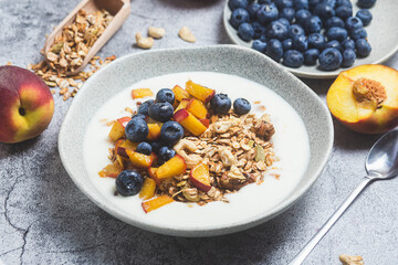Granola with yogurt, peach, blueberries in a plate 