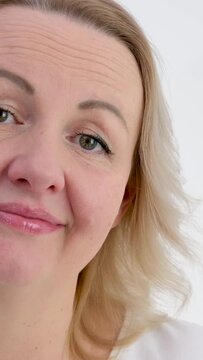 shake head no no shrug blonde woman on white background middle aged dissatisfied with something disappointed at same time smiling tenderly showing well 
