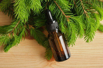 glass amber bottles with pipettes and spruce branches with young needles