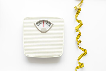 White floor weight scales with measuring tape. Body weight control and slimming concept