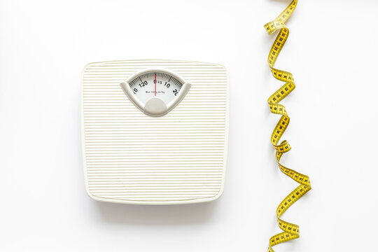 White floor weight scales with measuring tape. Body weight control and slimming concept