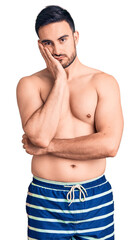 Fototapeta premium Young handsome man wearing swimwear thinking looking tired and bored with depression problems with crossed arms.