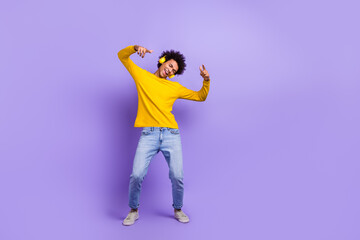 Fototapeta na wymiar Full length photo of crazy overjoyed person have good mood dancing listen music headphones empty space isolated on violet color background