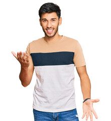 Young handsome man wearing casual clothes smiling cheerful with open arms as friendly welcome, positive and confident greetings