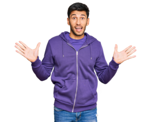 Young handsome man wearing casual sweatshirt celebrating victory with happy smile and winner expression with raised hands