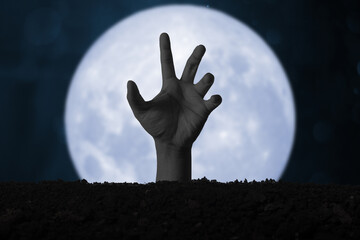 Halloween. Devil's hand emerges from the ground.